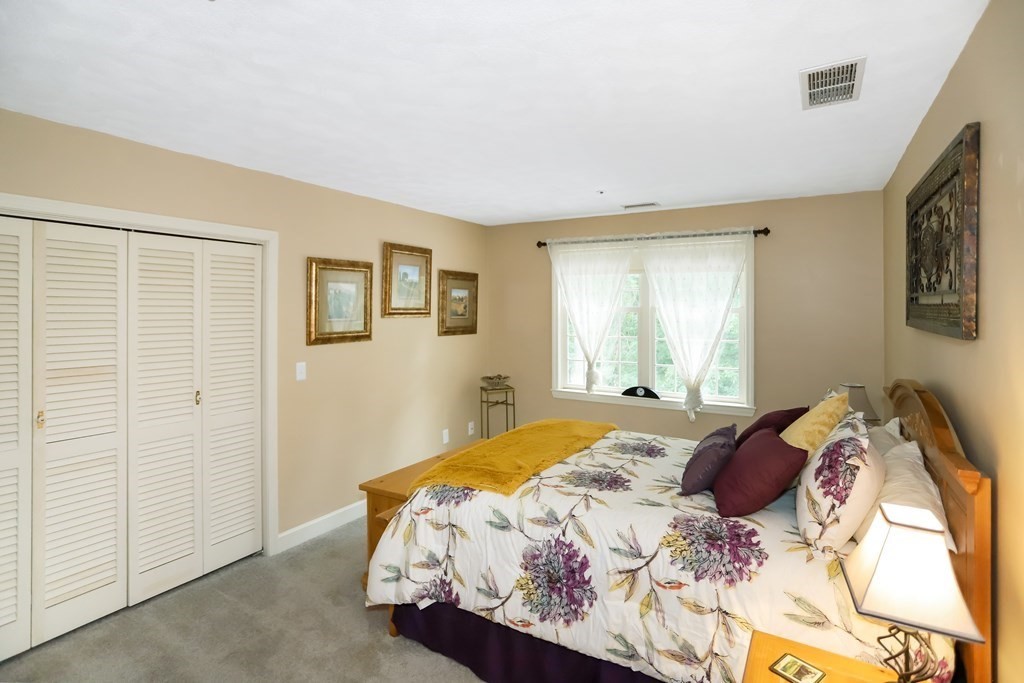 29 Lexington Drive, Unit 29 Atkinson, NH 03811 - Photo 24 of 31 a bedroom with a bed and a window