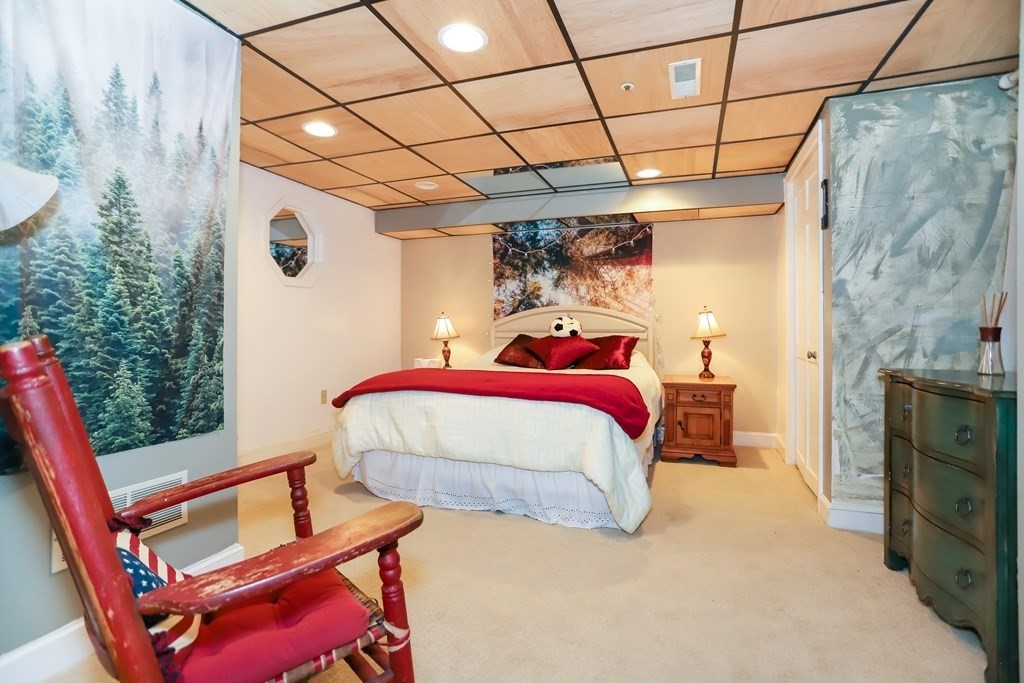 29 Lexington Drive, Unit 29 Atkinson, NH 03811 - Photo 27 of 31 a bedroom with a bed and a chair