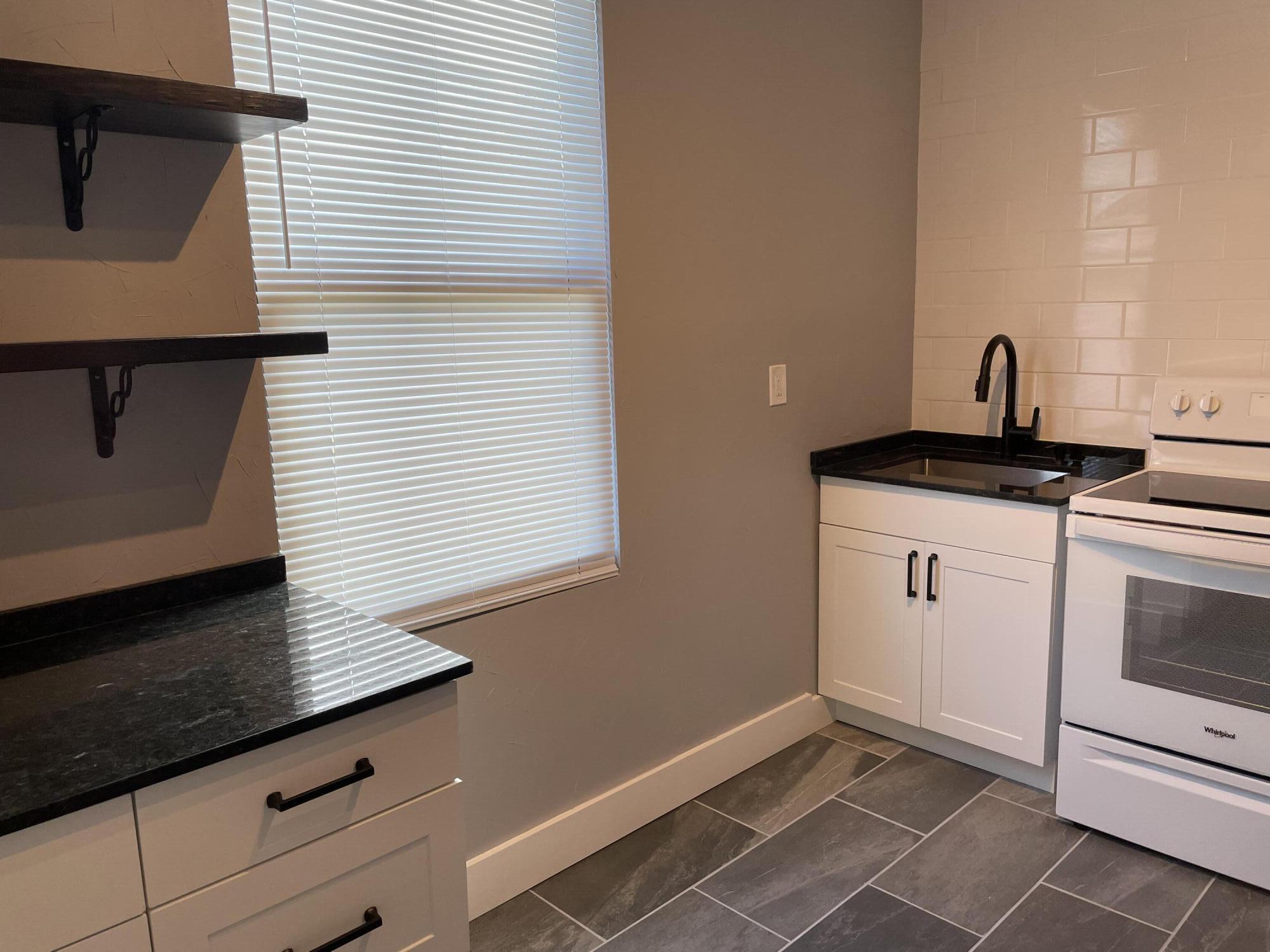 432 15th Street, Unit 2 West Palm Beach, FL 33401 - Photo 10 of 10 a kitchen with granite countertop a sink cabinets and stainless steel appliances