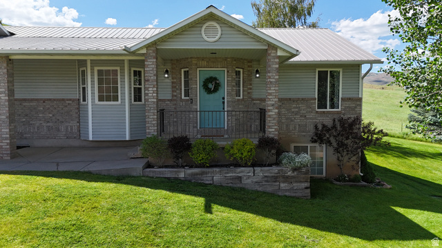 9029 North Treasureton Road Preston, ID 83263 - Photo 21 of 31 Front exterior featuring light blue siding with brick veneer accents and a metal roof
