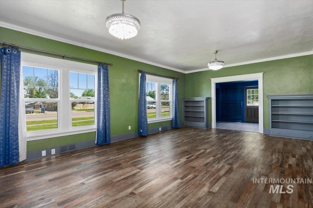 813 7th Street Rupert, ID 83350 - Photo 11 of 48 Spacious interior featuring wood-finish flooring, multiple windows, built-in shelving, and two ceiling-mounted light fixtures