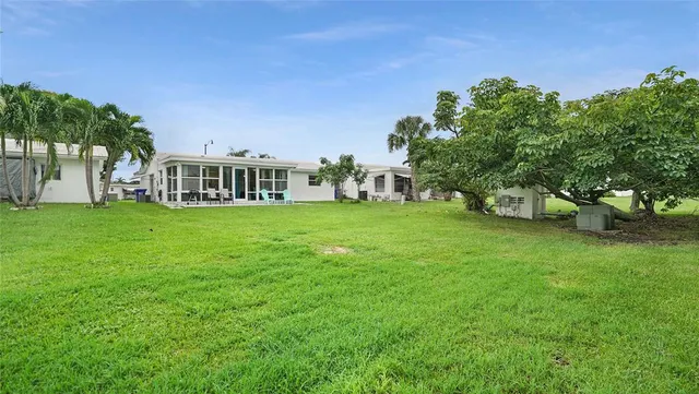 a view of a house with a big yard and large trees