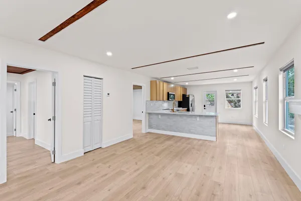a view of a big room with wooden floor and windows