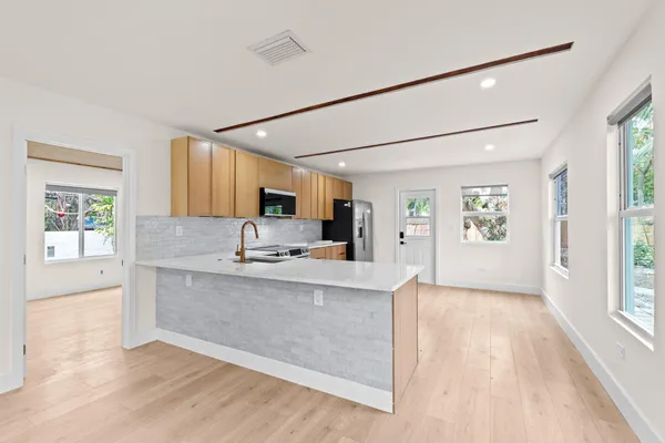 a large kitchen with cabinets and a wooden floor