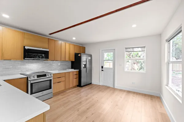 a kitchen with stainless steel appliances granite countertop a stove a sink and a refrigerator