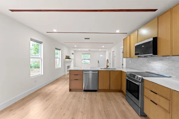 a large kitchen with stainless steel appliances granite countertop a stove and a sink