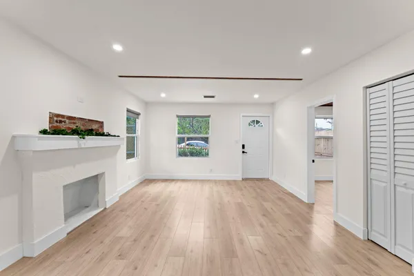 an empty room with a fireplace and wooden floor