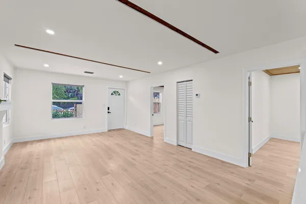 a view of an empty room with wooden floor