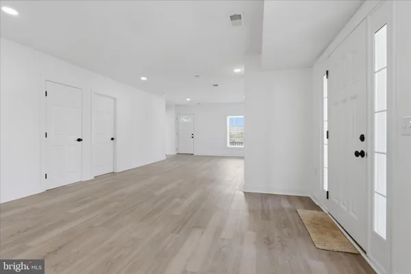a view of an empty room with wooden floor