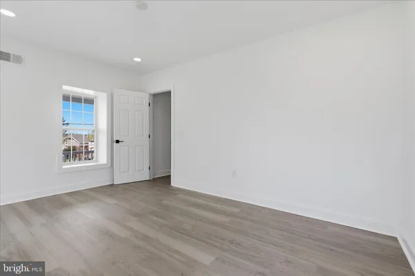 an empty room with wooden floor and a window