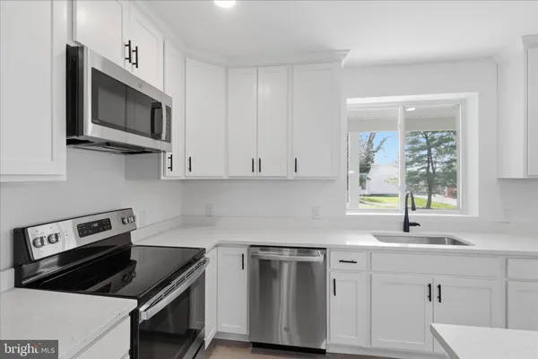 a view of a kitchen with wooden floor and electronic appliances