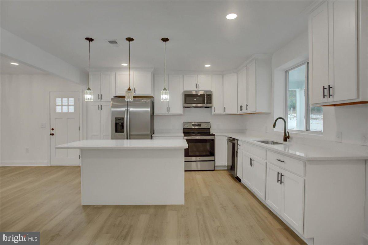 50 St Paul Street Boonsboro, MD 21713 - Photo 29 of 81 a large white kitchen with stainless steel appliances granite countertop a stove a sink a refrigerator and white cabinets with wooden floor