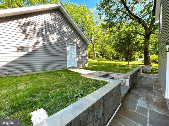 a view of a backyard with side of the house