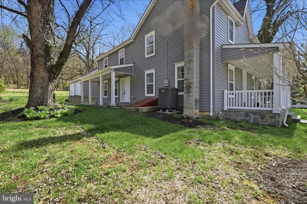 a view of a house with backyard and a tree