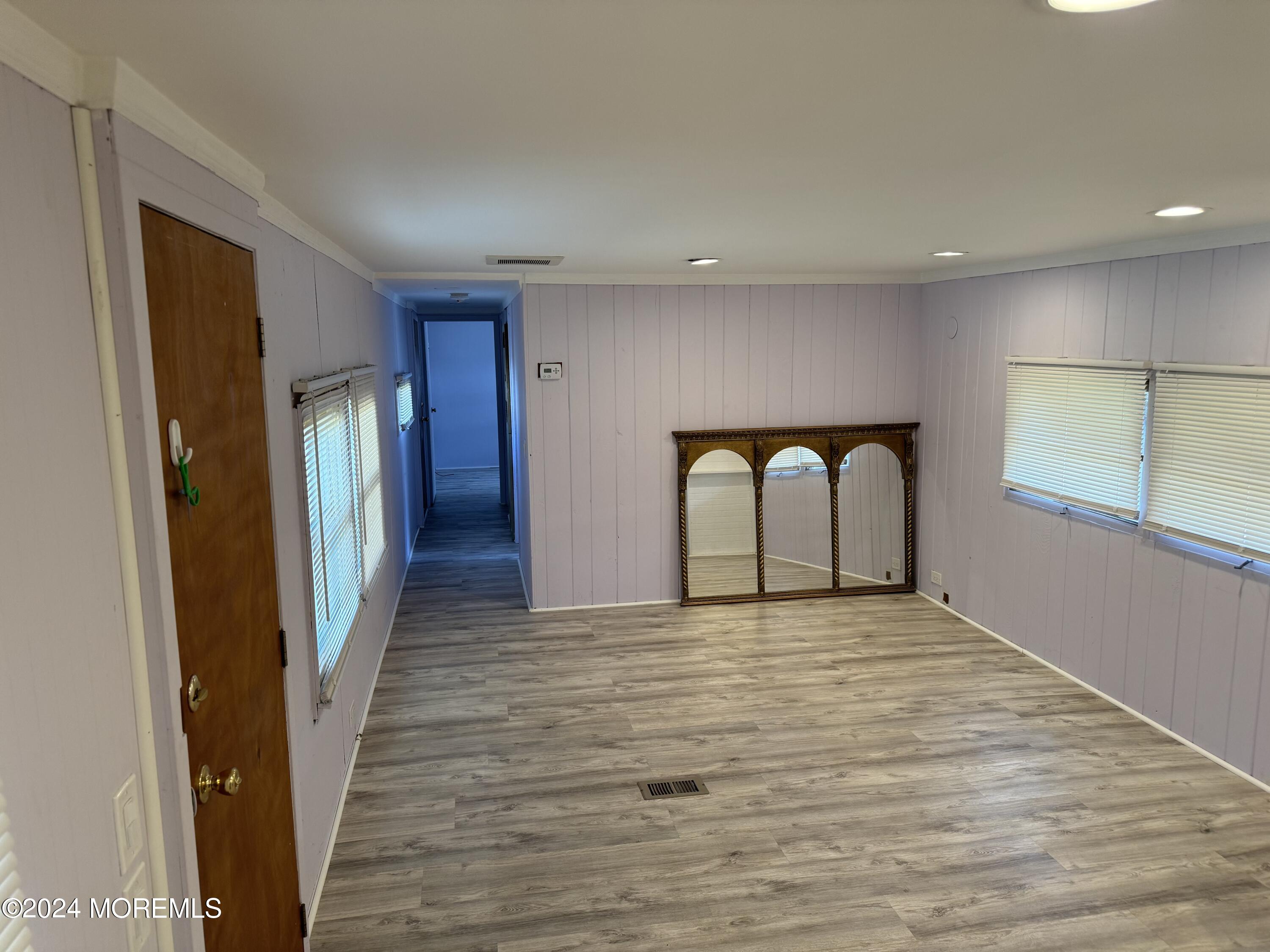 127 Lane B Hazlet, NJ 07730 - Photo 2 of 6 a view of an empty room with wooden floor and a window
