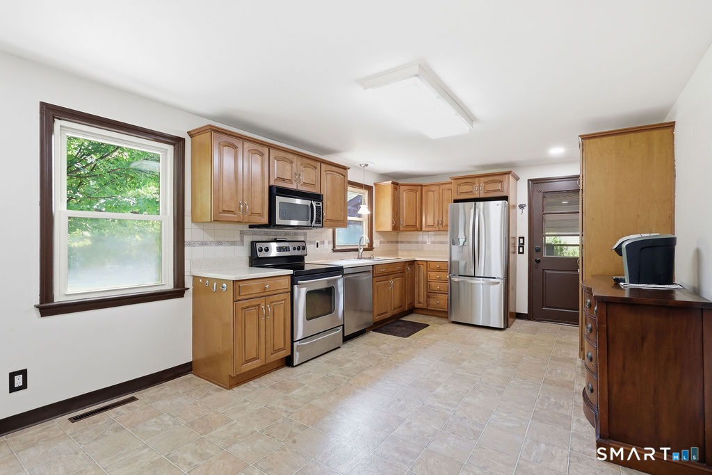 630 South Elm Street Wallingford, CT 06492 - Photo 10 of 30 a kitchen with stainless steel appliances granite countertop a refrigerator a stove top oven a sink dishwasher and wooden cabinets