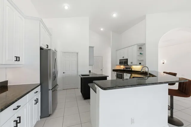 a spacious bedroom with a bed and a flat screen tv