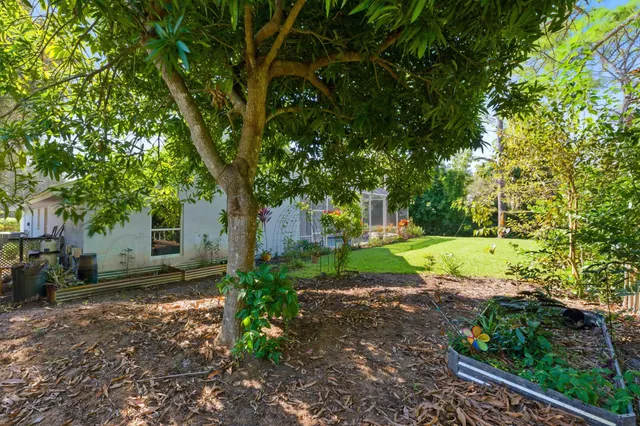 an aerial view of residential houses with outdoor space and trees