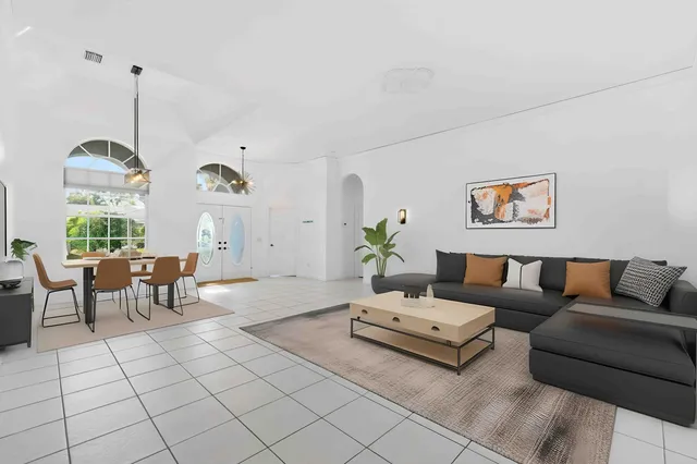 a living room with furniture a fireplace and a floor to ceiling window