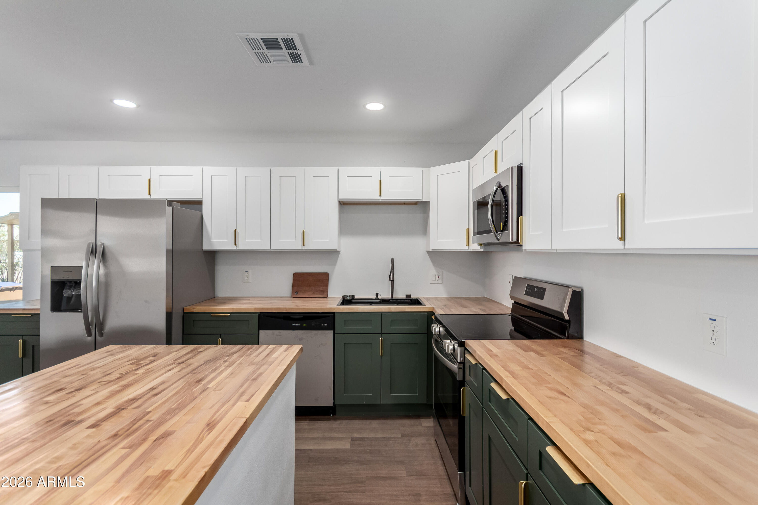 9155 West Adams Street Tolleson, AZ 85353 - Photo 3 of 29 a kitchen with stainless steel appliances granite countertop a refrigerator sink and stove