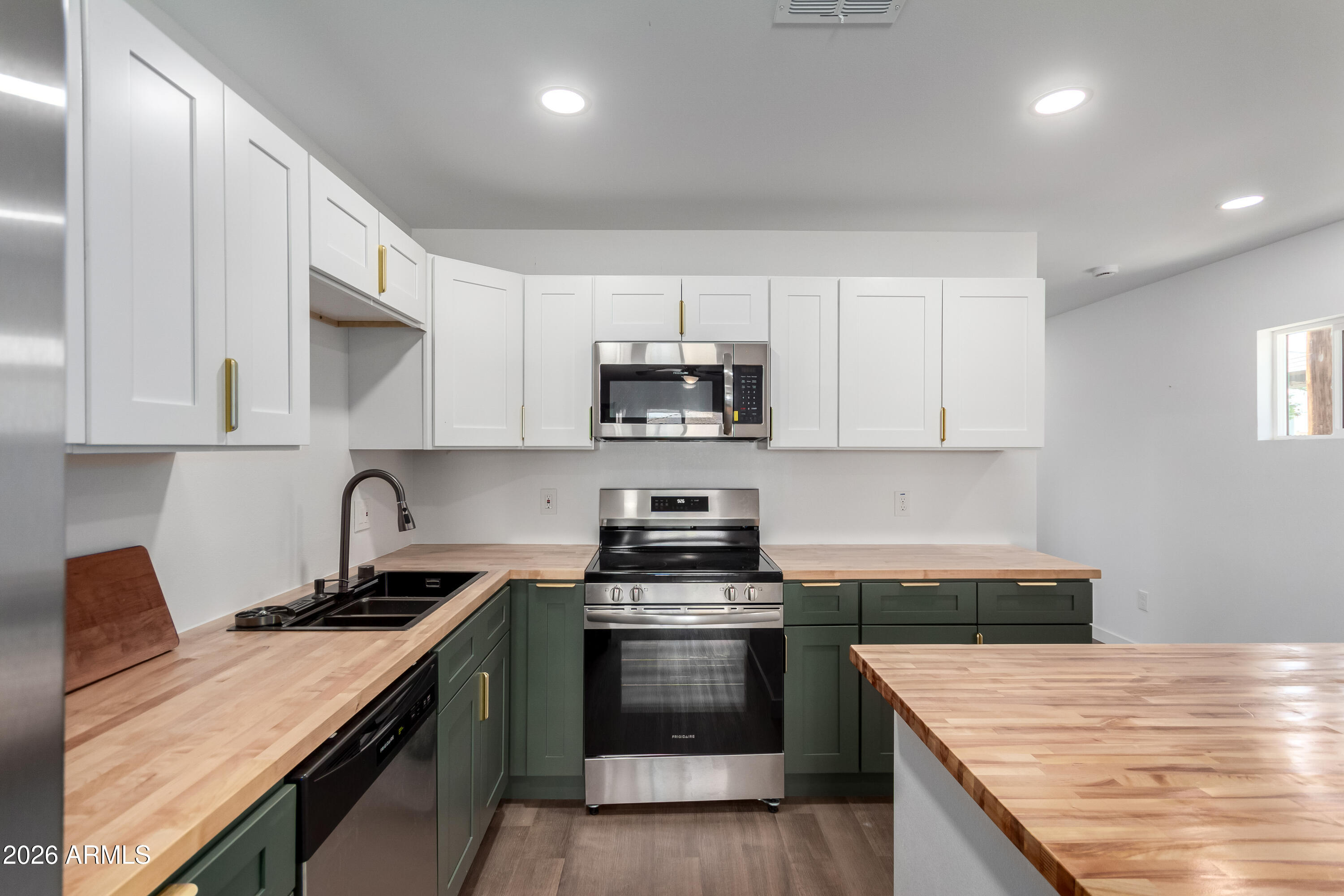 9155 West Adams Street Tolleson, AZ 85353 - Photo 4 of 29 a kitchen with granite countertop white cabinets and stainless steel appliances