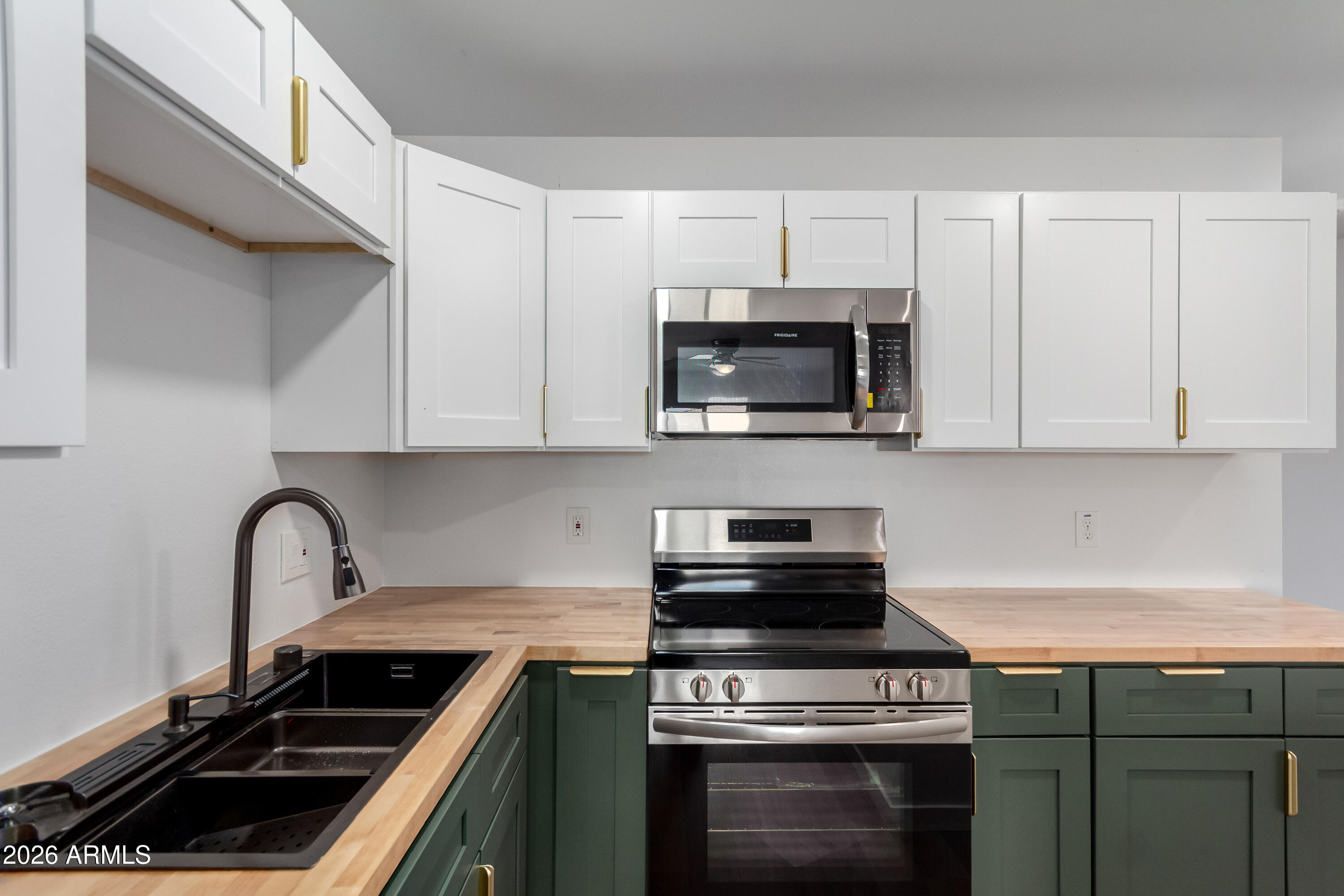 9155 West Adams Street Tolleson, AZ 85353 - Photo 8 of 29 a kitchen with cabinets stainless steel appliances a sink and a stove