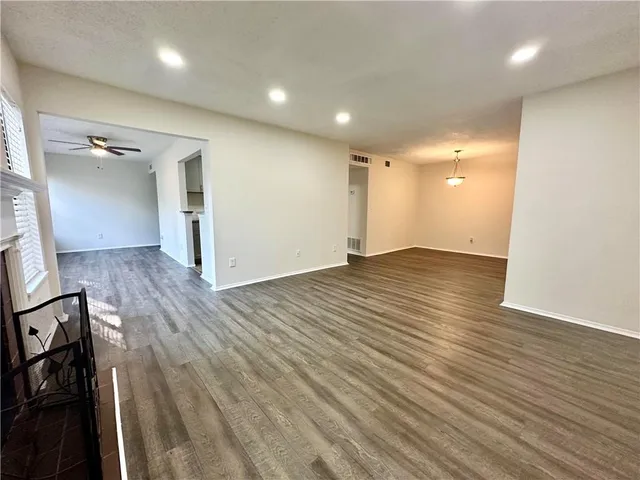 an empty room with wooden floor and entrance