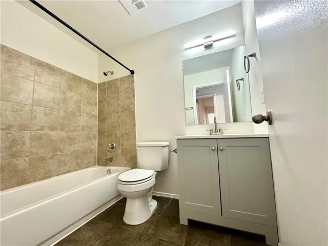a bathroom with a sink toilet a mirror and bathtub