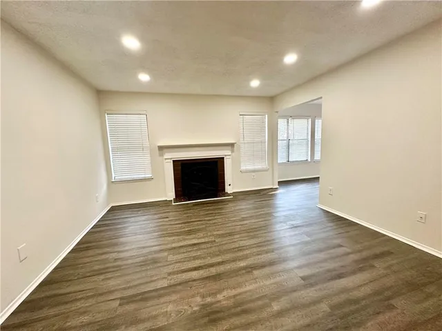 an empty room with wooden floor and fireplace