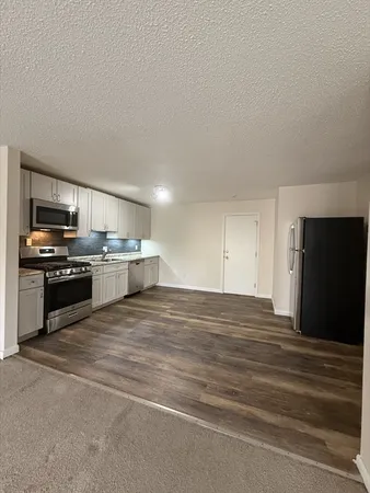 a kitchen with stainless steel appliances kitchen island granite countertop a stove and a refrigerator