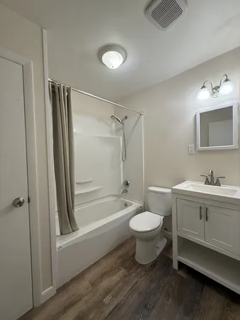 a bathroom with a granite countertop toilet a sink and a bathtub