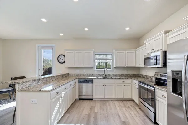 a kitchen with a sink stove cabinets and refrigerator