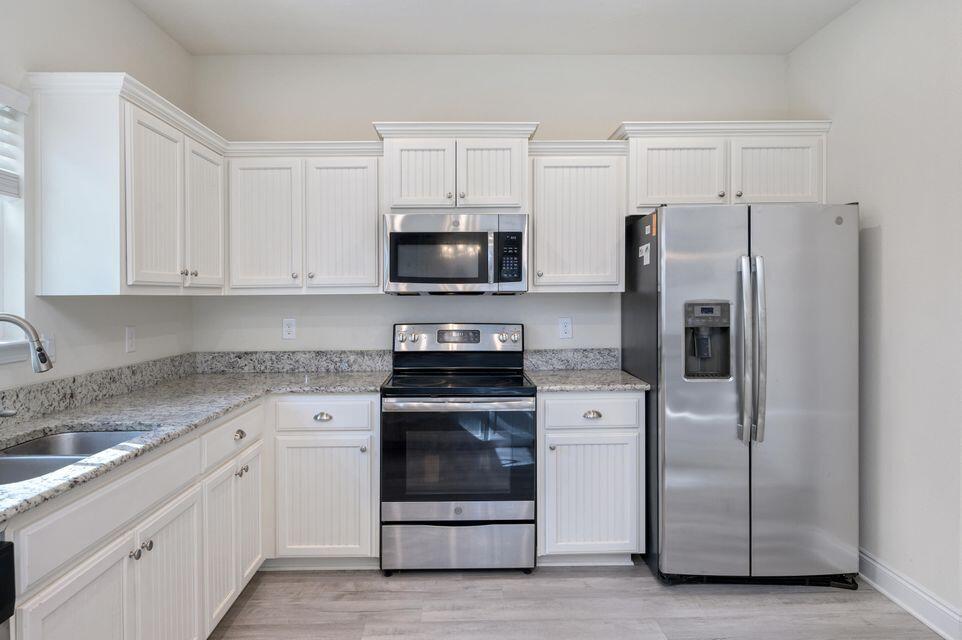 43 Brandywine Road Freeport, FL 32439 - Photo 5 of 23 a kitchen with white cabinets and stainless steel appliances