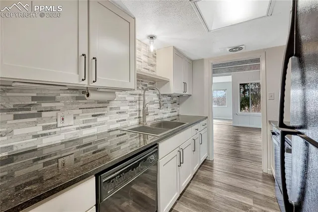 a kitchen with granite countertop a sink and cabinets