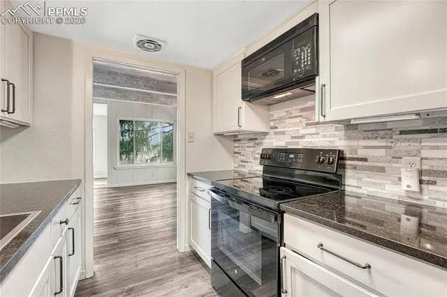 a kitchen with granite countertop a stove and a wooden floor
