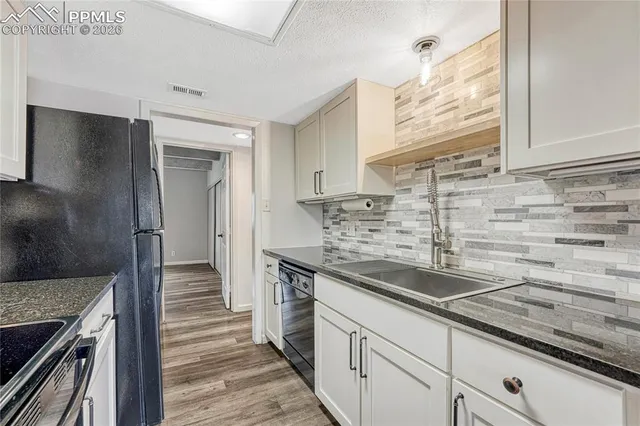 a kitchen with stainless steel appliances granite countertop a sink and a stove