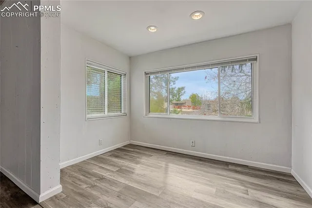 a view of empty room with window and wooden floor