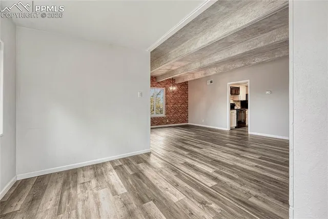 a view of empty room with wooden floor