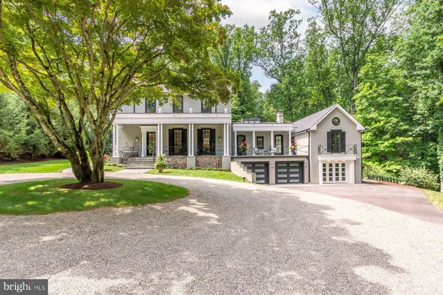 a patio with a table and chairs and potted plants