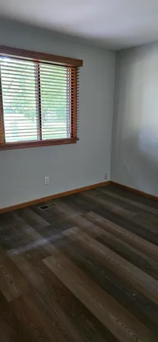 a view of a room with wooden floor and a window