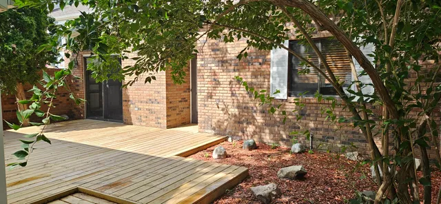 a view of a wooden floor and a trees in the background