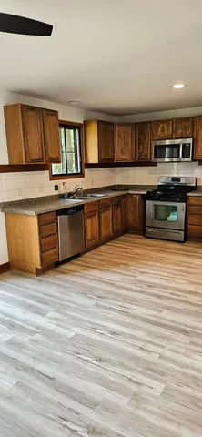 a kitchen with stainless steel appliances kitchen island granite countertop a large counter top and cabinets