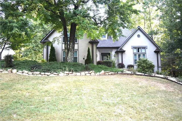 a front view of a house with yard and green space
