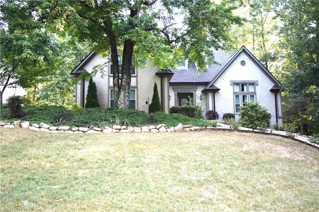 a front view of a house with yard and green space
