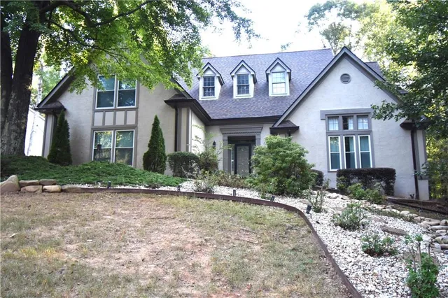 a front view of a house with a yard and potted plants