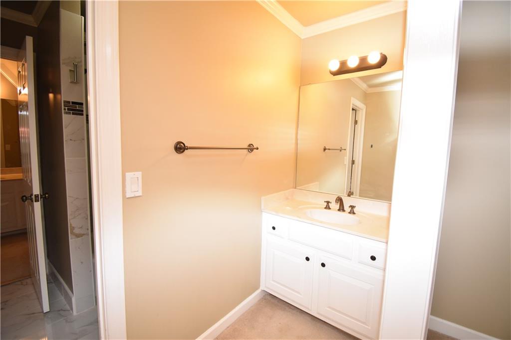 7700 Wickley Way Atlanta, GA 30350 - Photo 26 of 58 a bathroom with a double vanity sink a mirror and a shower