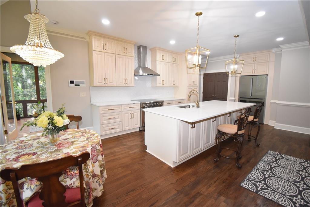 7700 Wickley Way Atlanta, GA 30350 - Photo 10 of 58 a kitchen with a dining table chairs sink and white cabinets