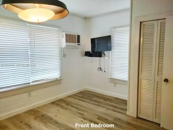 a view of a livingroom with wooden floor and a flat screen tv