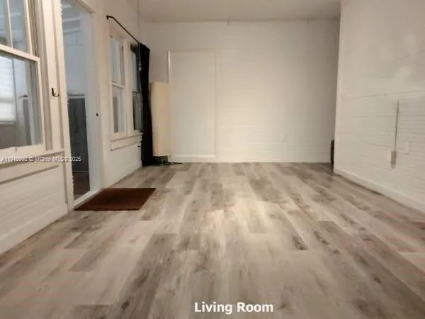 a view of a room with wooden floor and white walls