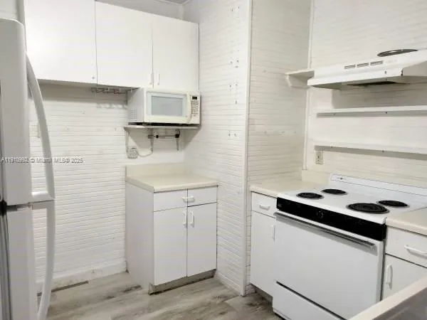 a kitchen with a cabinets and white appliances